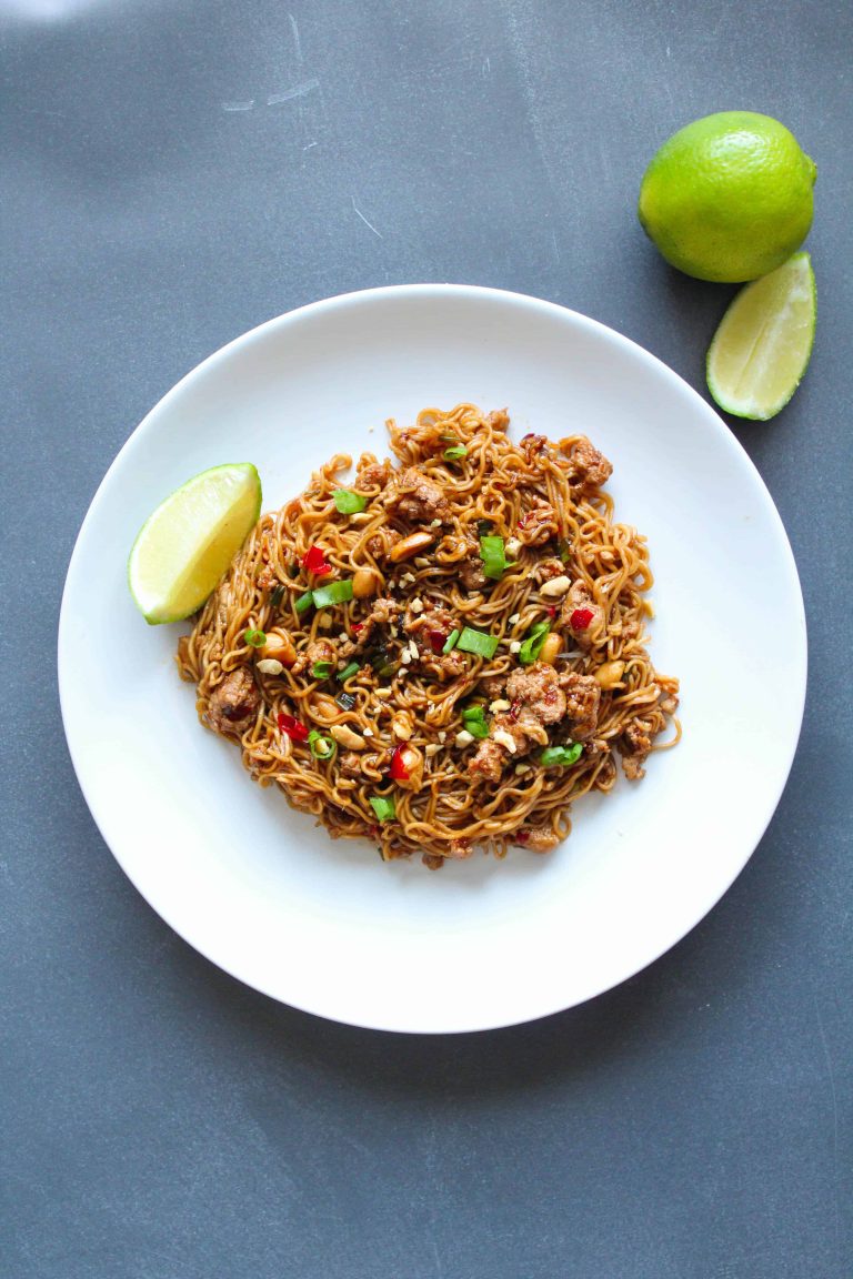 Thai Chicken Noodles on a plate with a lime wedge next to it