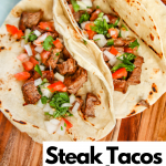 Steak Tacos with Pico de gallo as a topping. Tacos are on wooden serving platter surrounded by pico and limes.