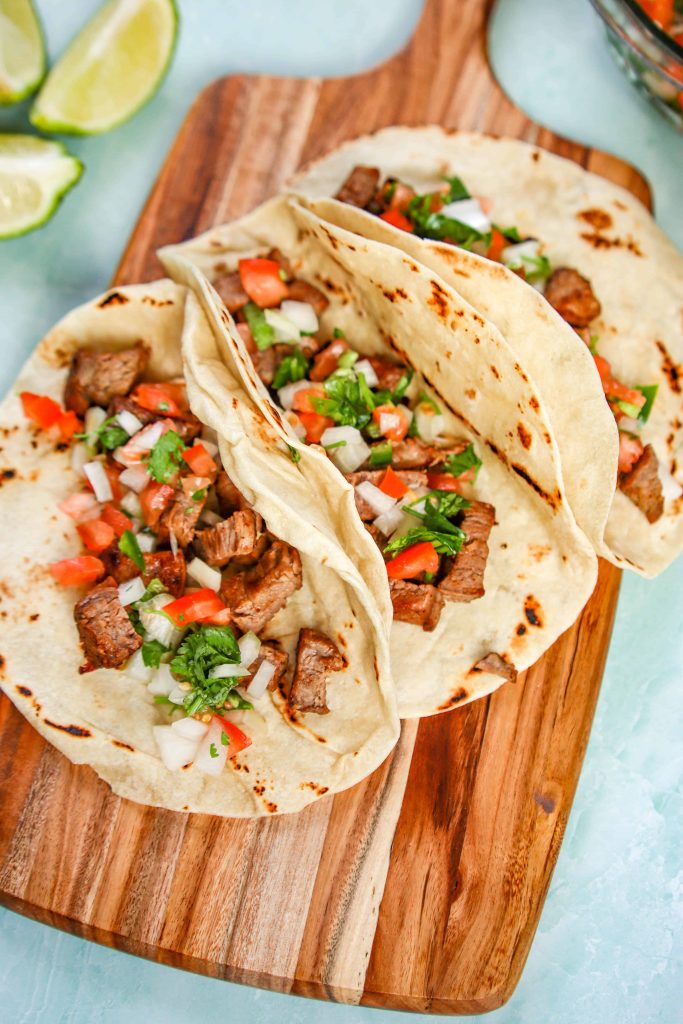 Steak Tacos with Pico on a wooden board 