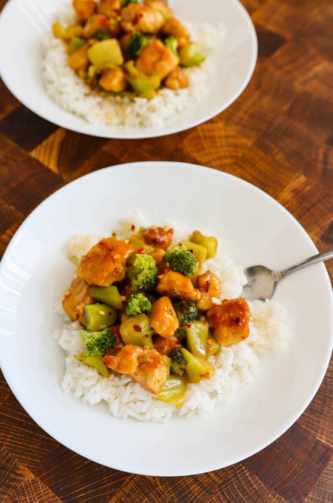 Easy Healthy Orange Chicken over rice in a while bowl.