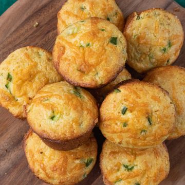 Jiffy Jalapeno Cornbread Muffins on a wooden board with honey butter