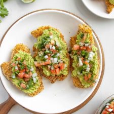 Crispy topped with Pico de Gallo Chicken and smashed avocado. surrounded by limes and cilantro