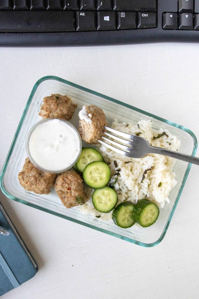 Greek Turkey Meatballs with Rice in a meal prep container 