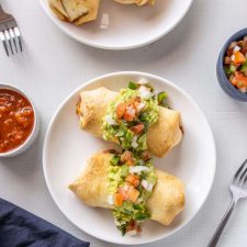 Baked Chimichangas covered in avocado