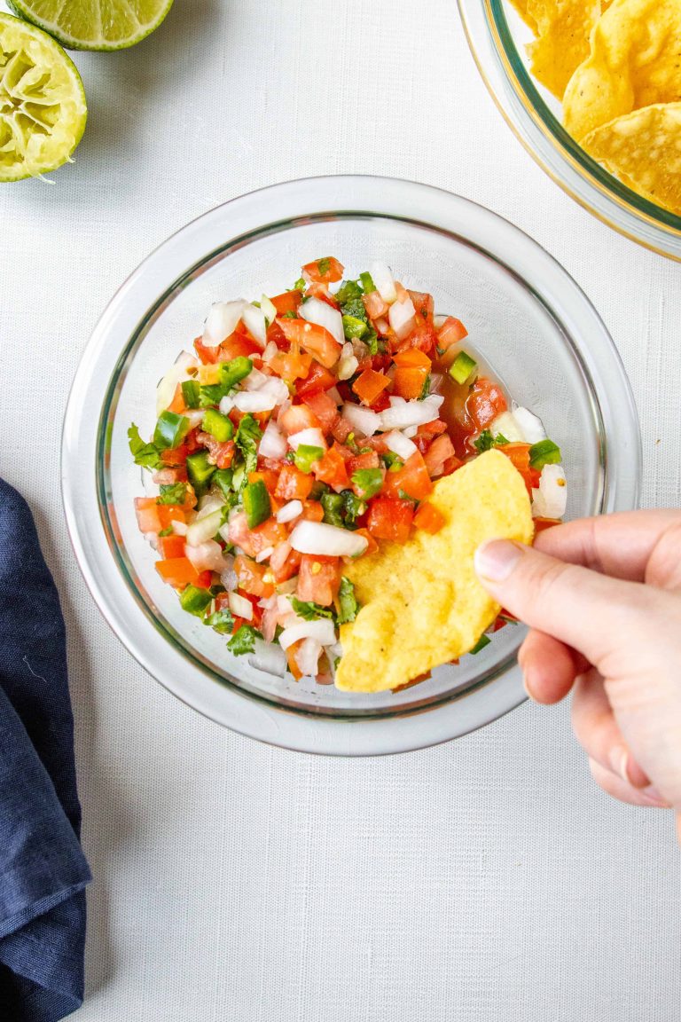 Pico de Gallo in a bowl with a chip