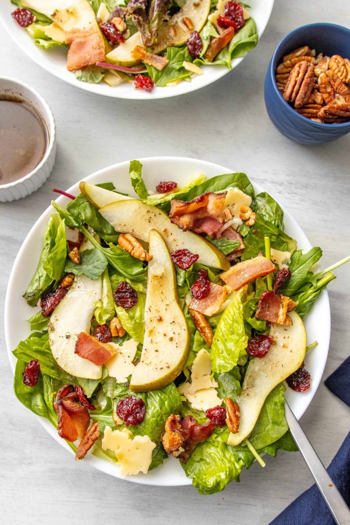 Salad with pears, made with bacon, pears, walnuts, dried cherries, and gouda cheese. 