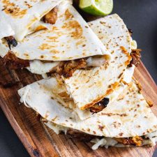 carnitas quesadilla on a wooden serving platter.