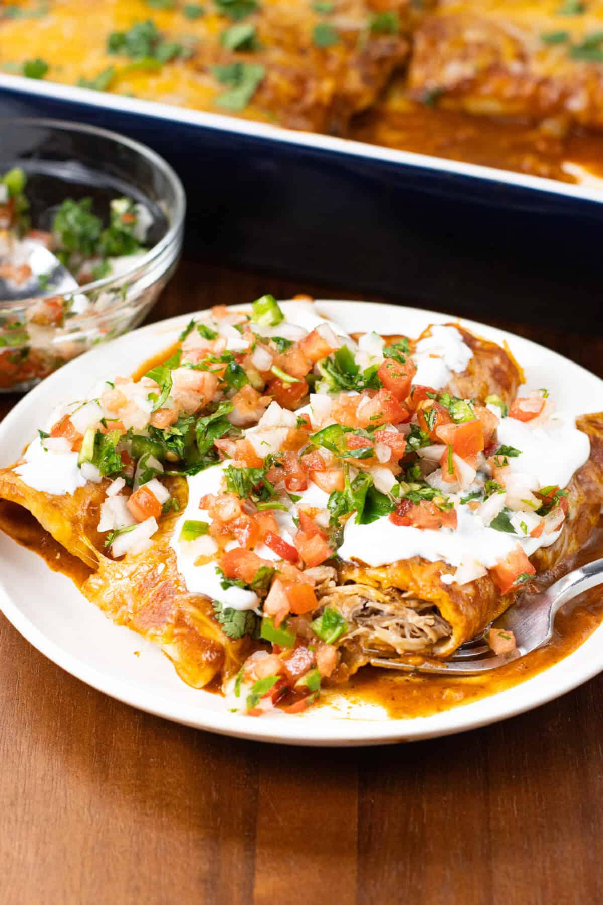 Pork Carnitas Enchiladas Recipe on plate with pan