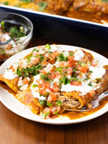 Pork Carnitas Enchiladas Recipe on plate with pan