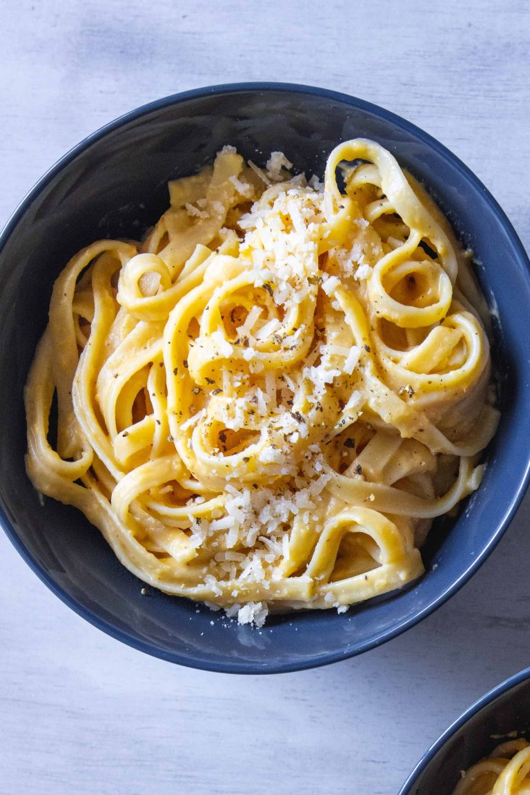 Butternut Squash Alfredo in a blue bowl with extra parmesan cheese on top.