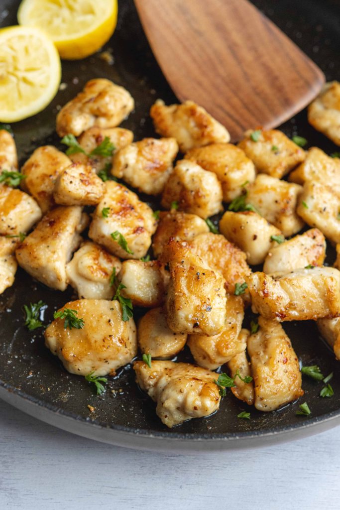  Lemon Pepper Chicken Bites in a skillet with lemons 