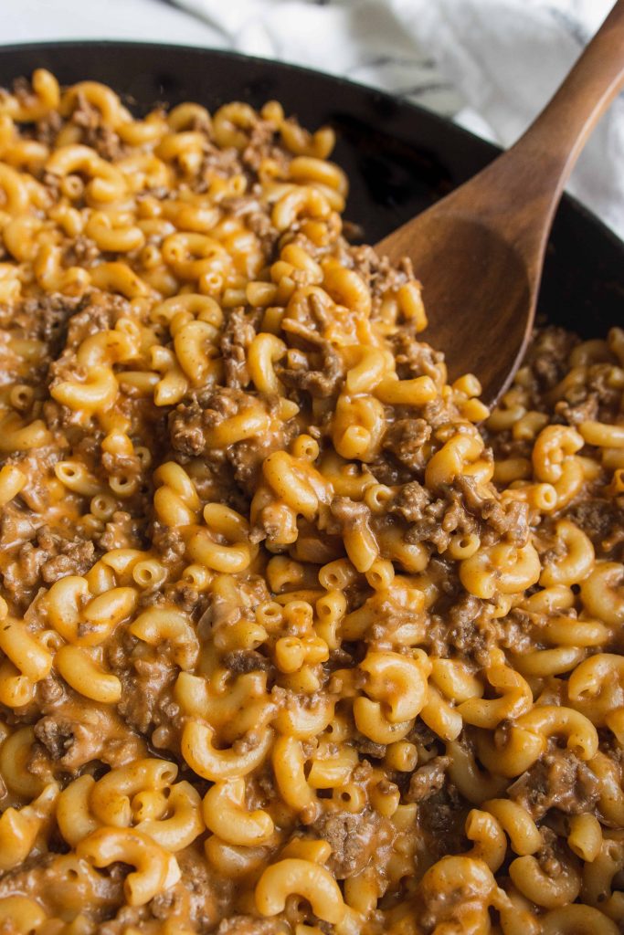 Homemade Hamburger Helper  in a skillet with a wooden spoon