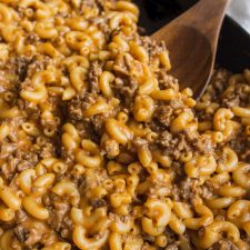 Homemade Hamburger Helper in a skillet with a wooden spoon