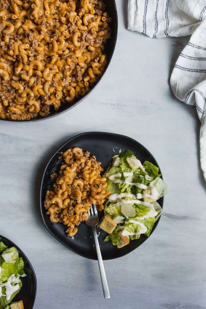 Homemade Hamburger Helper in a skillet with a wooden spoon