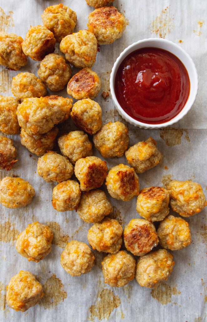 Healthy Baked Chicken Meatballs  on a sheet pan with ketchup