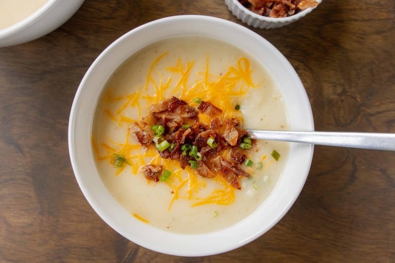 4 Ingredient Potato Soup in a bowl topped with bacon, cheese, and green onions