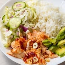 Spicy Salmon Bowl: Rice, salmon, avocado and pickled vegetables in a bowl, covered in spicy mayo.