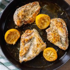 chicken in cast iron skillet with lemons