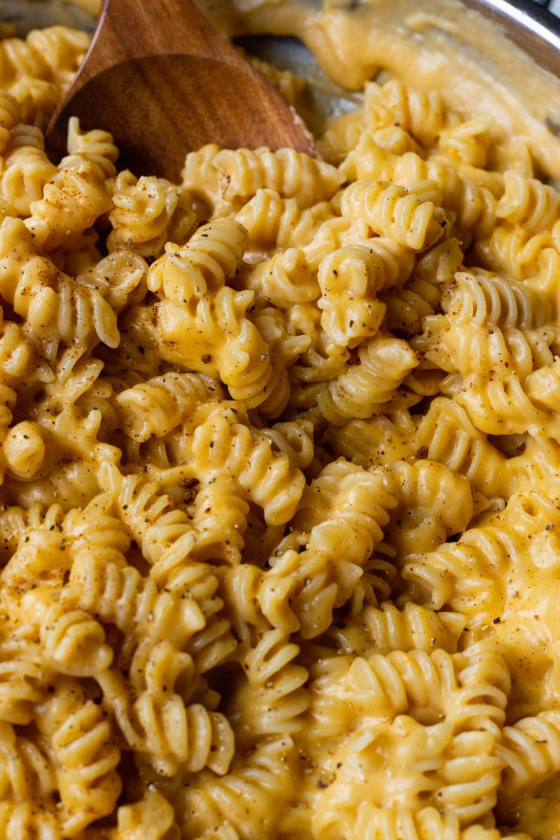 Easy Pumpkin Mac and Cheese   with a wooden spoon