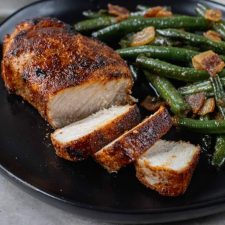 Broiled Pork Chops Cut up on a plate with green beans