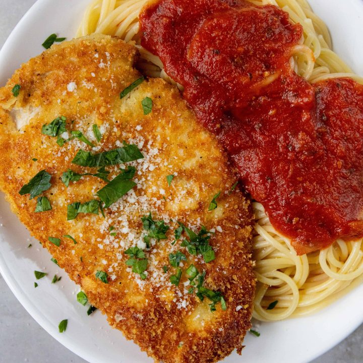 Crusted Chicken Romano next to spaghetti