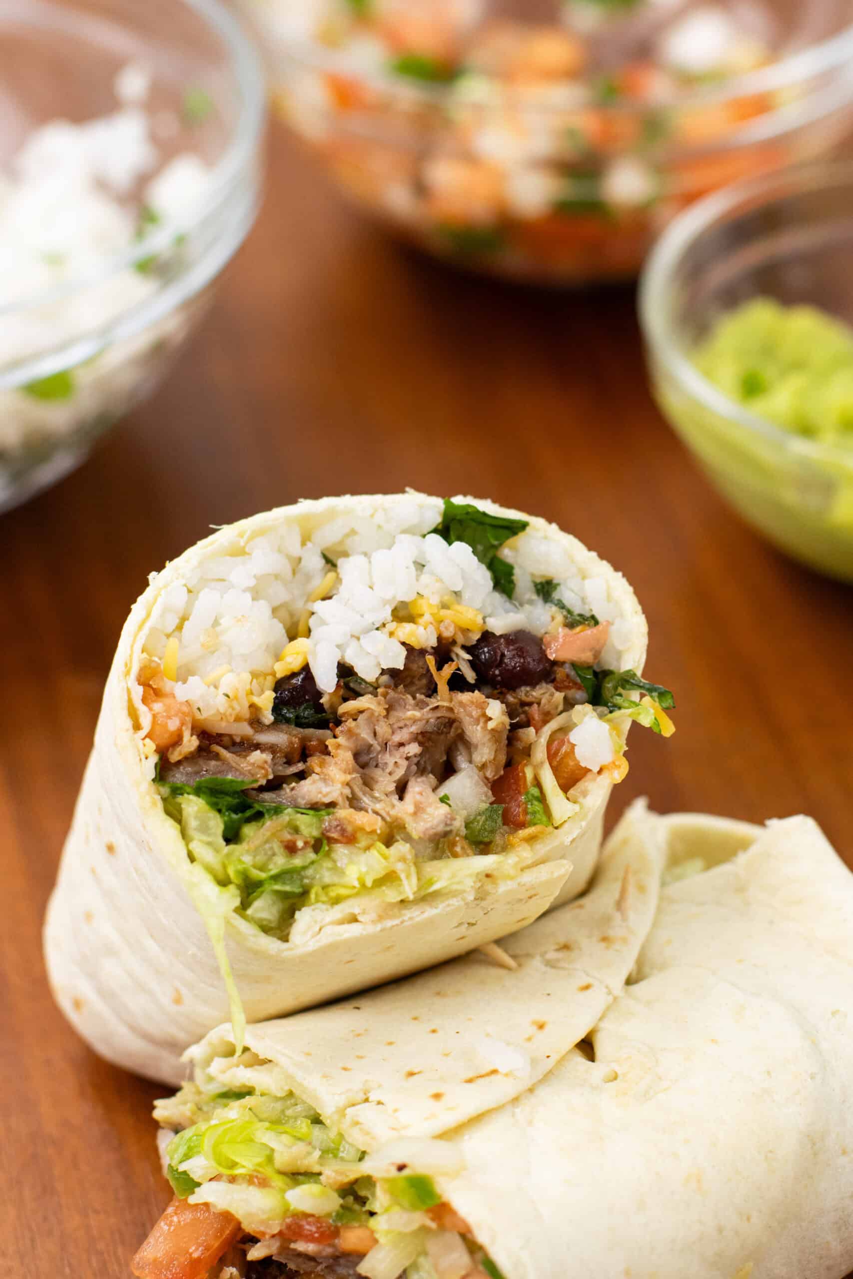 carnitas burritos finished with filling in the background