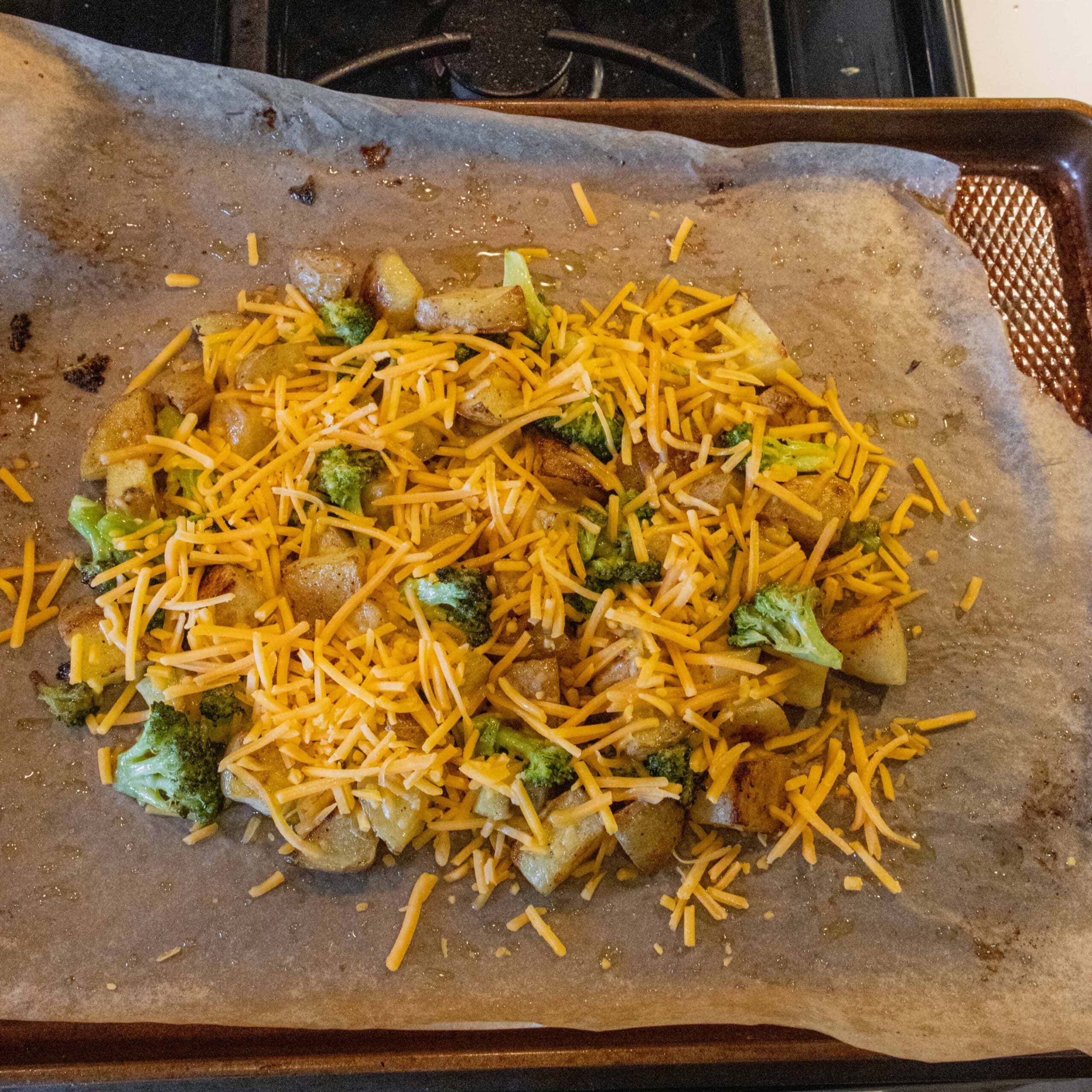 potatoes and broccoli with cheese on a sheet pan