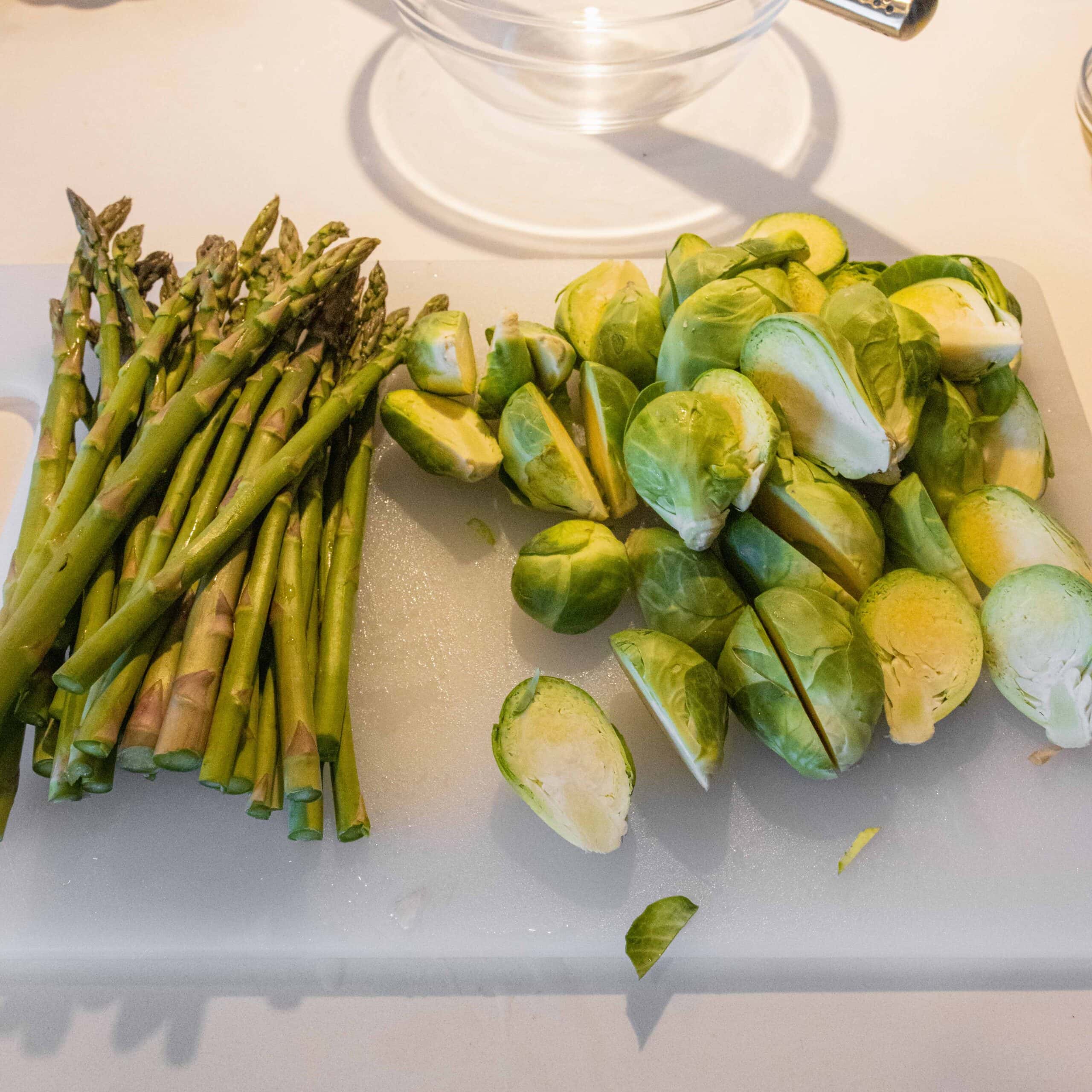 asparagus and brussels sprouts on a cutting board
