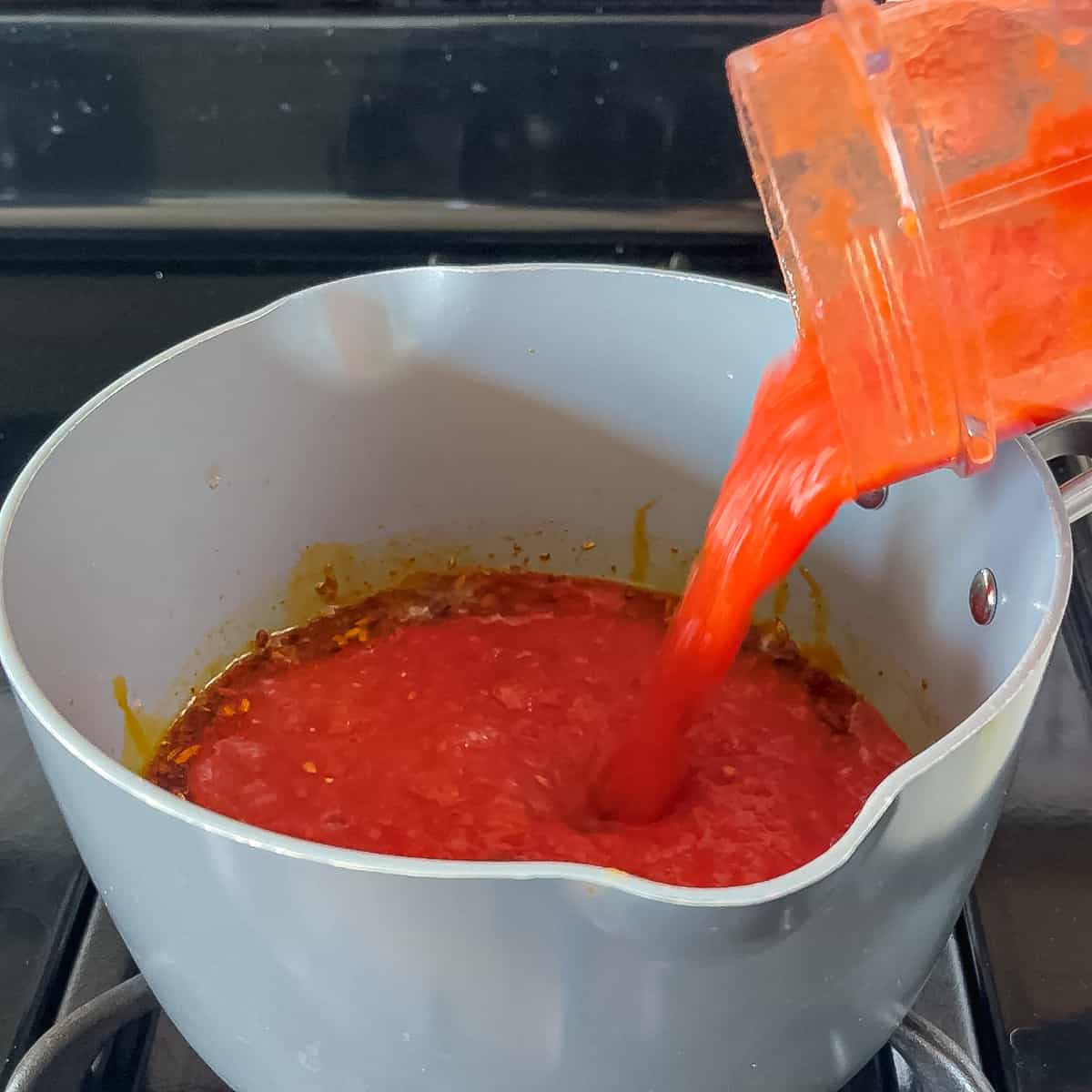 tomato sauce going into pot