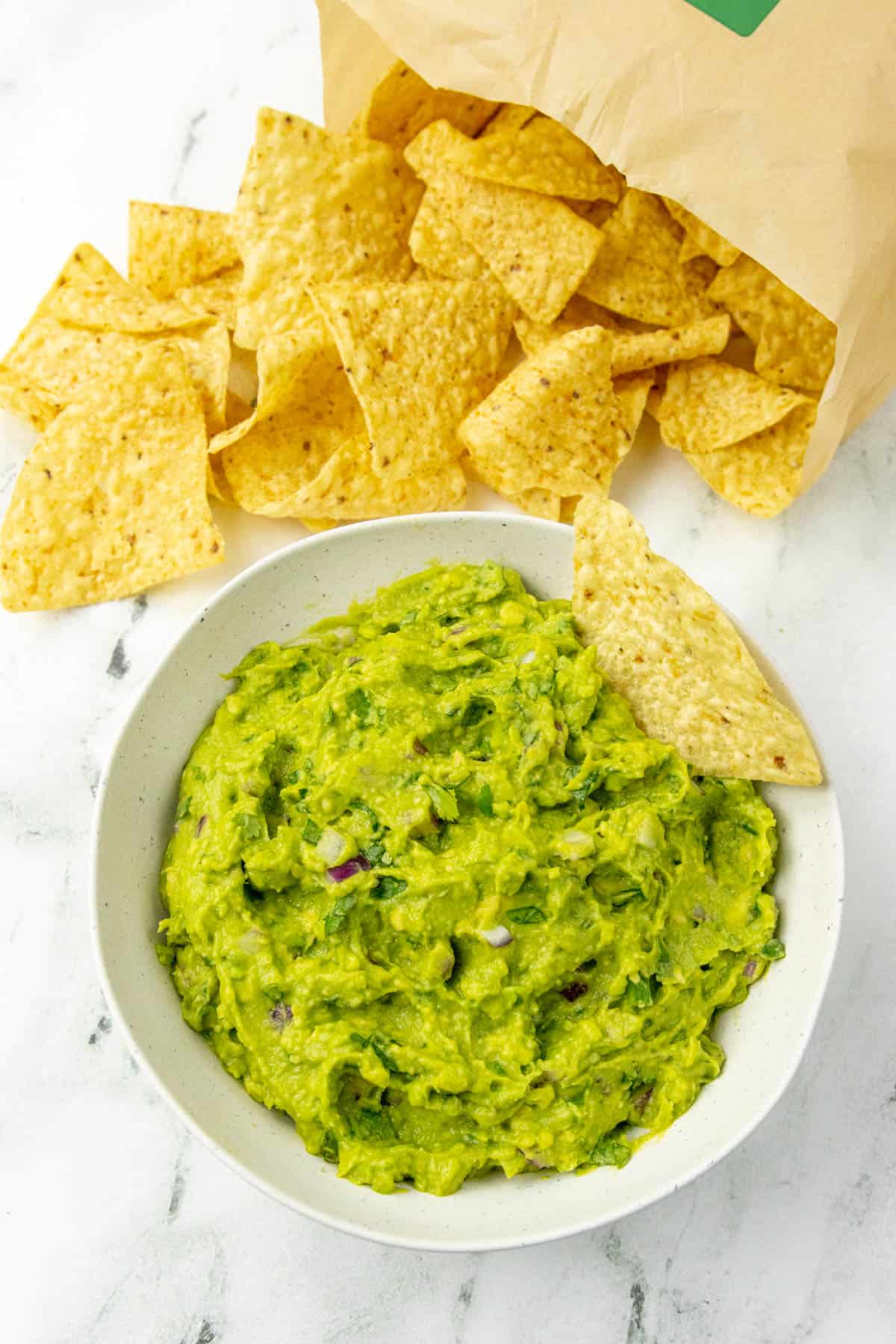 Guacamole with chips dipped in it