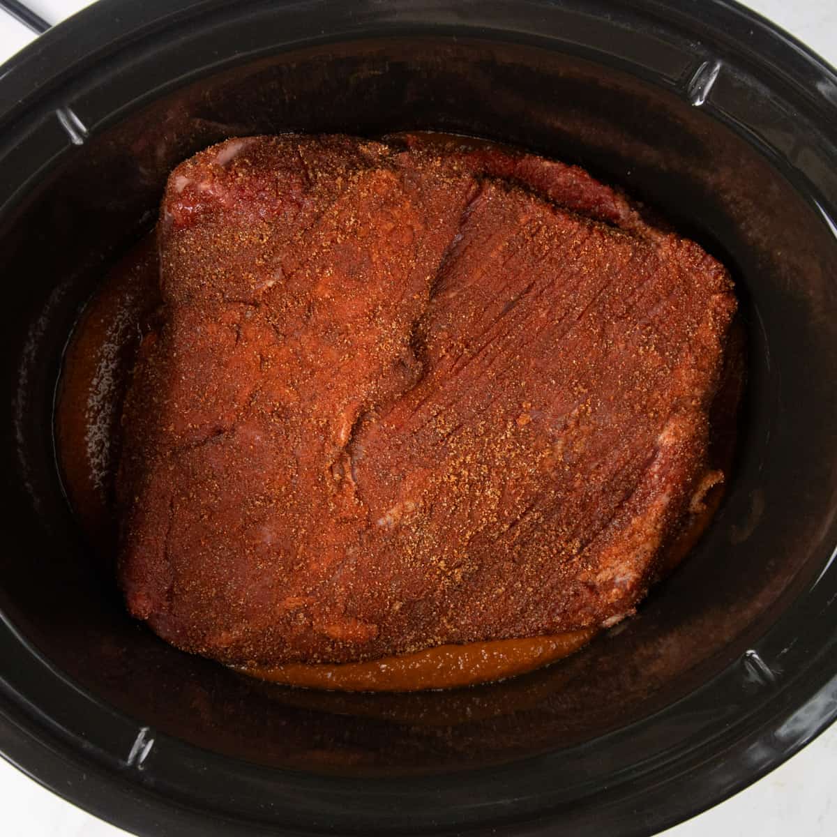 un cooked brisket in slowcooker