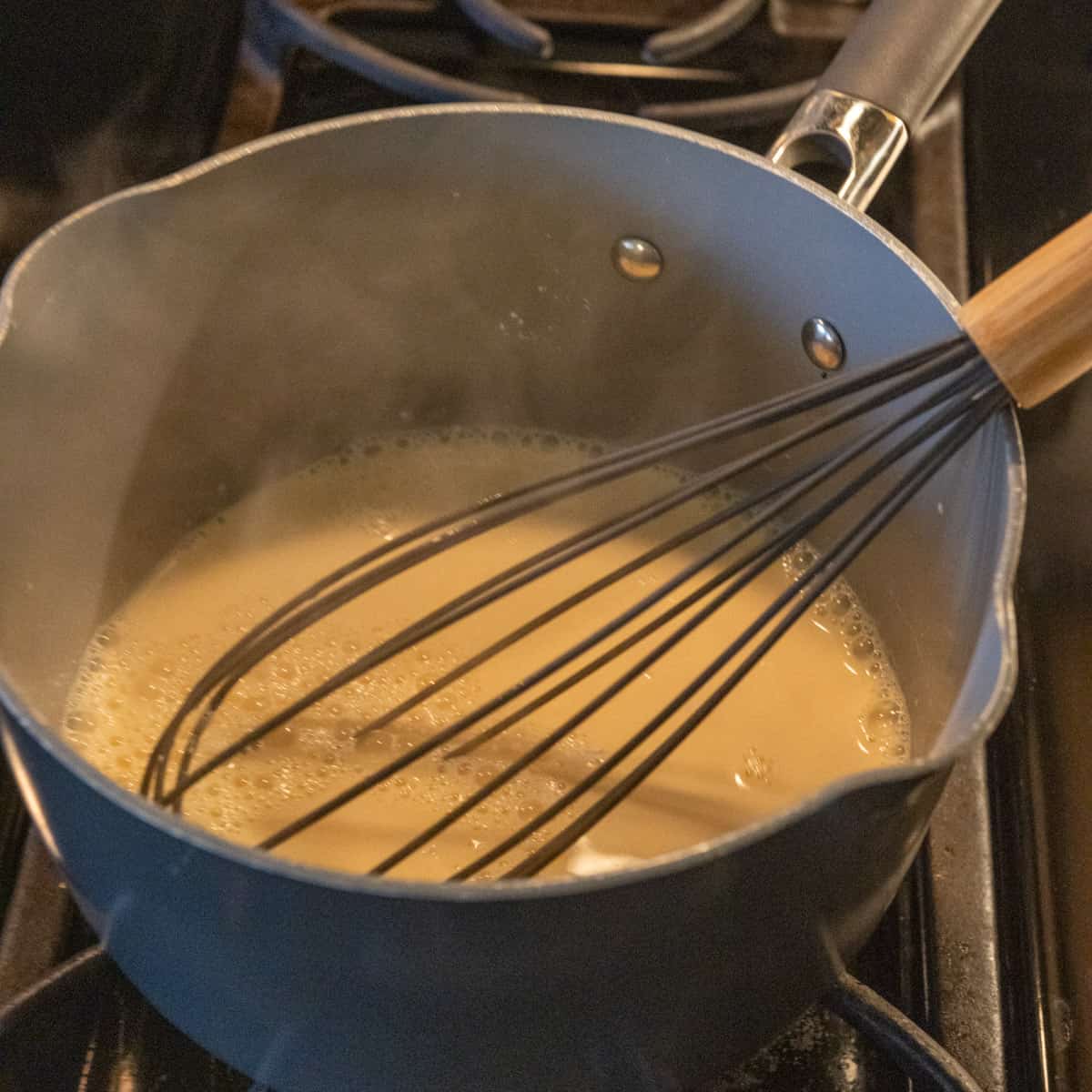 Warming milk in a pot with a whisk