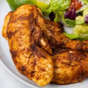 southwest chicken tenderloins on a plate next to salad