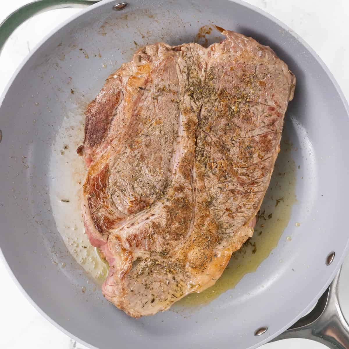 chuck roast cooking in pan