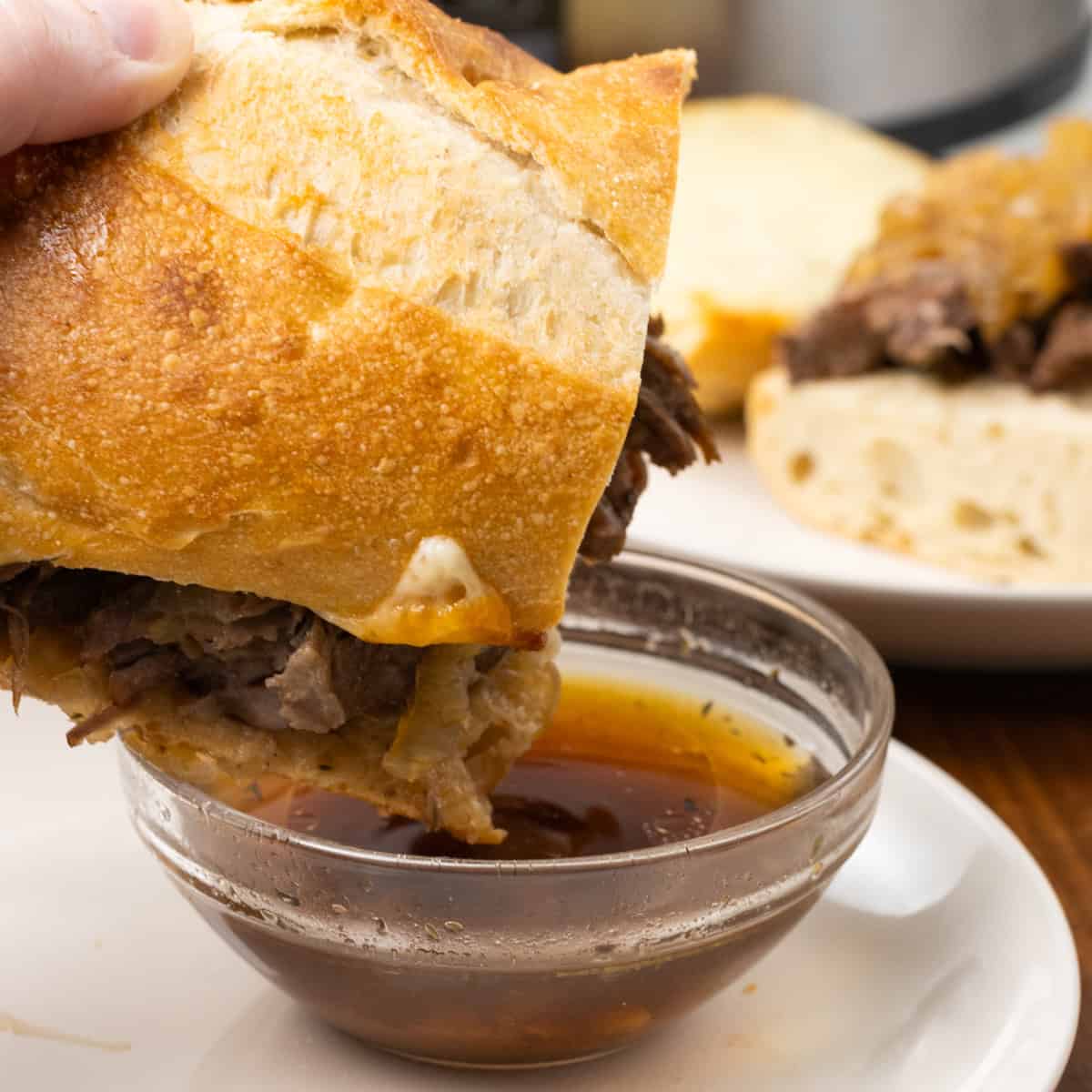 Crock Pot French Dip Sandwich dipped in broth