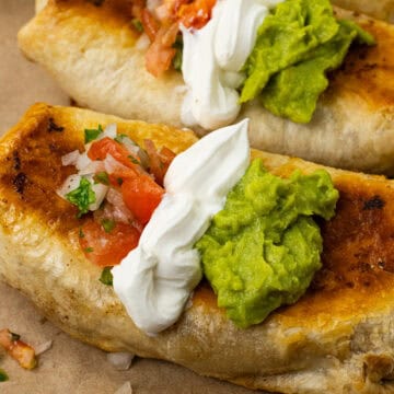 close up of finished grind beef chimichangas with guacamole, sour cream, and pico de Gallo