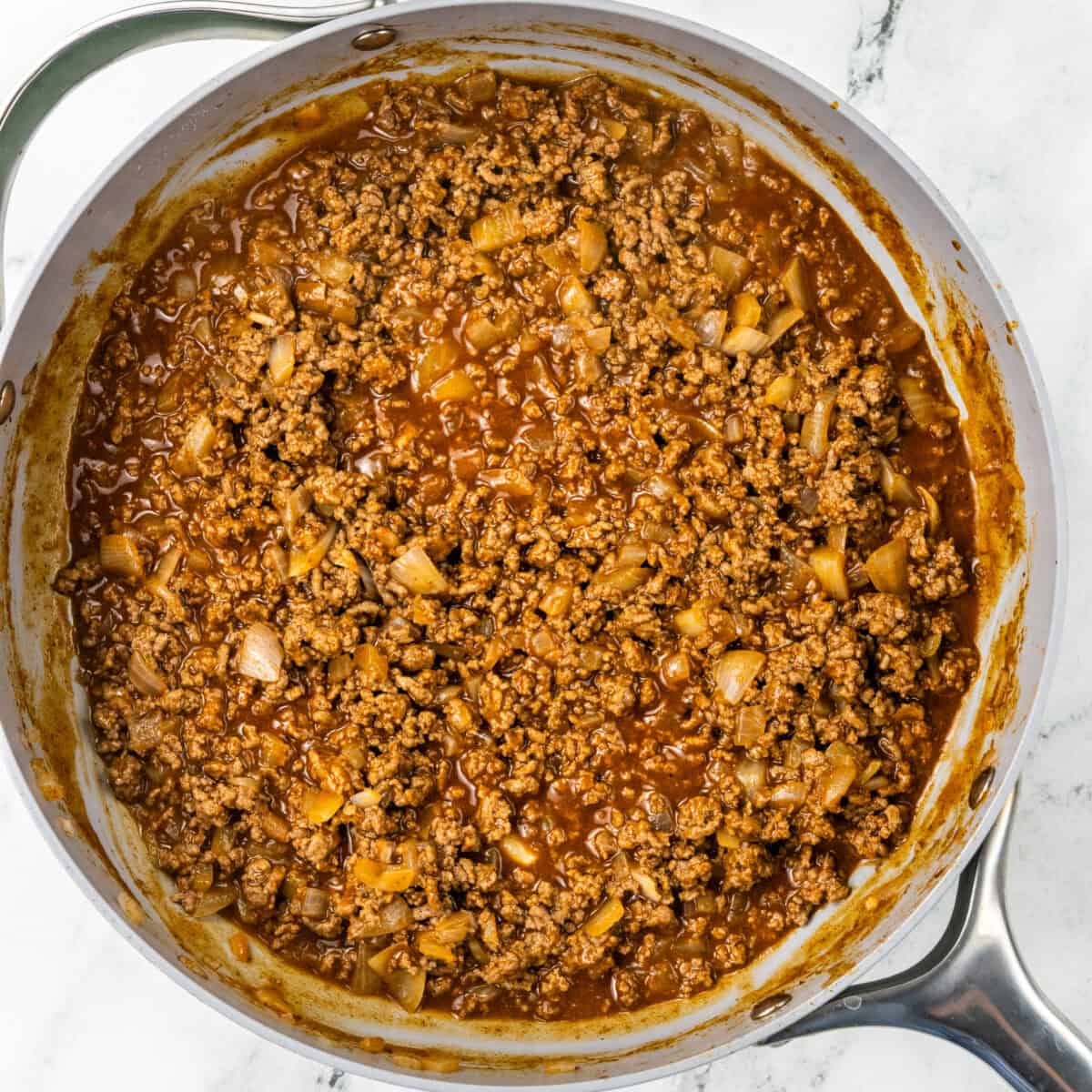 Combining sauce and beef for 30 Minute One Pan Beef Enchilada Skillet recipe