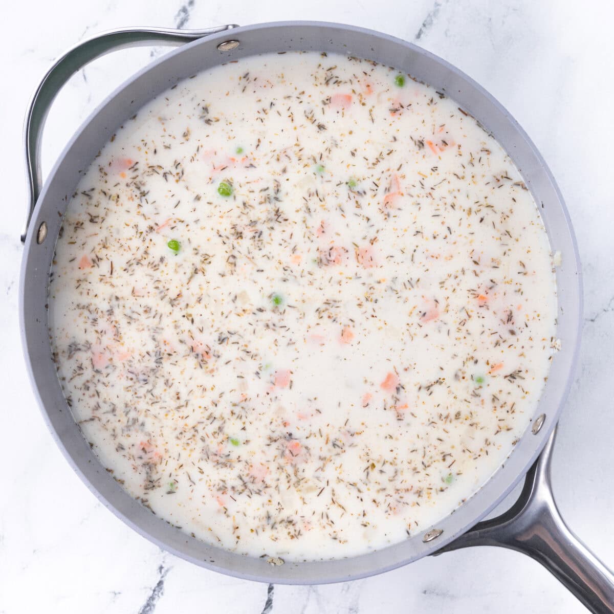 milk, broth, and veggies added to pan of chicken noddle pasta recipe