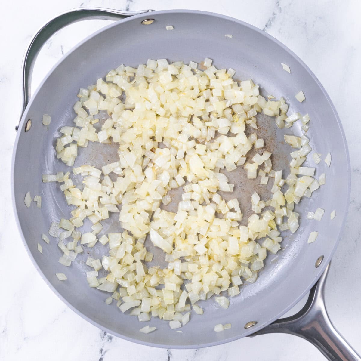 cooking diced onion that will be used in chicken noodle pasta