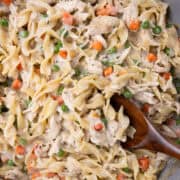 close up of wooden spoon in pan of chicken noodle pasta
