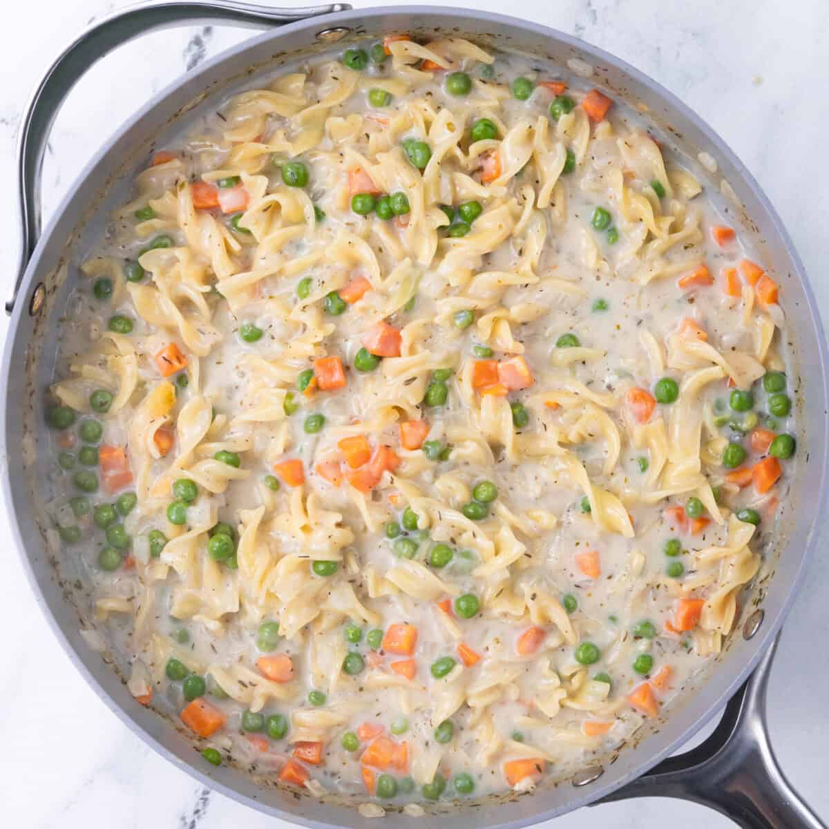simmering pan of chicken noodle pasta