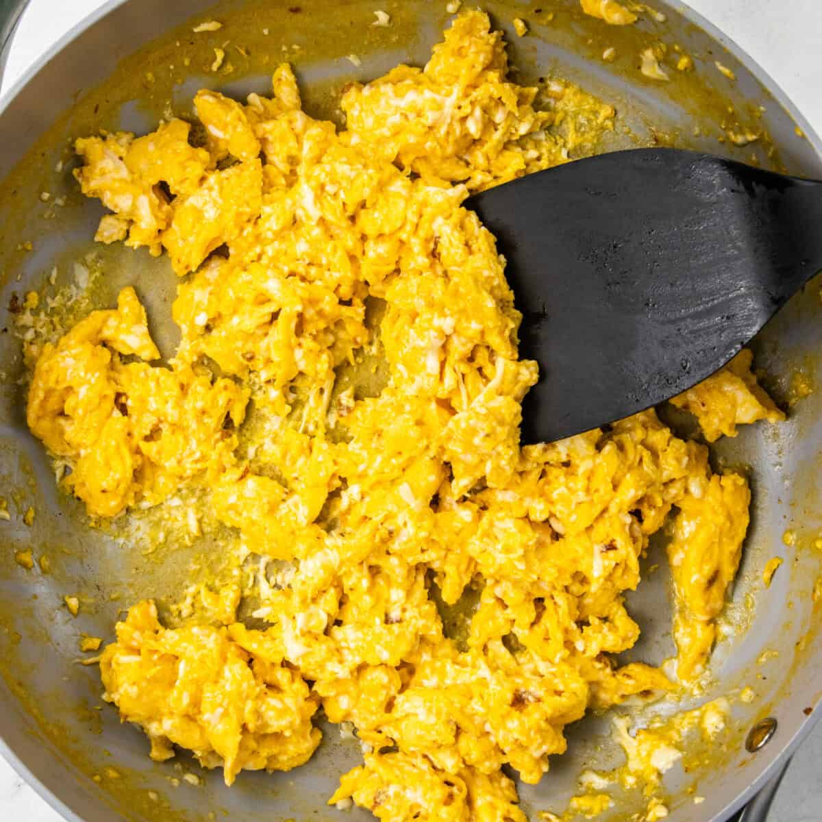 cooking eggs in a pan with a spatula for Chorizo Potato Egg and Cheese Breakfast Tacos