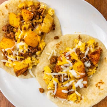 finished tacos on a white plate for Chorizo Potato Egg and Cheese Breakfast Tacos