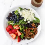 Summer Berry Salad with Feta and Candied Pecans in a bowl with vinaigrette