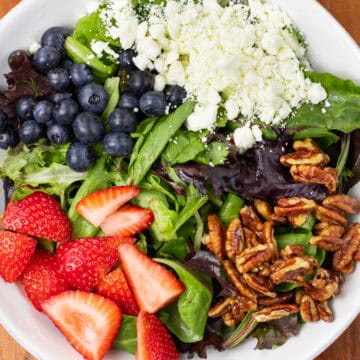 Summer Berry Salad with Feta and Candied Pecans in a bowl finished