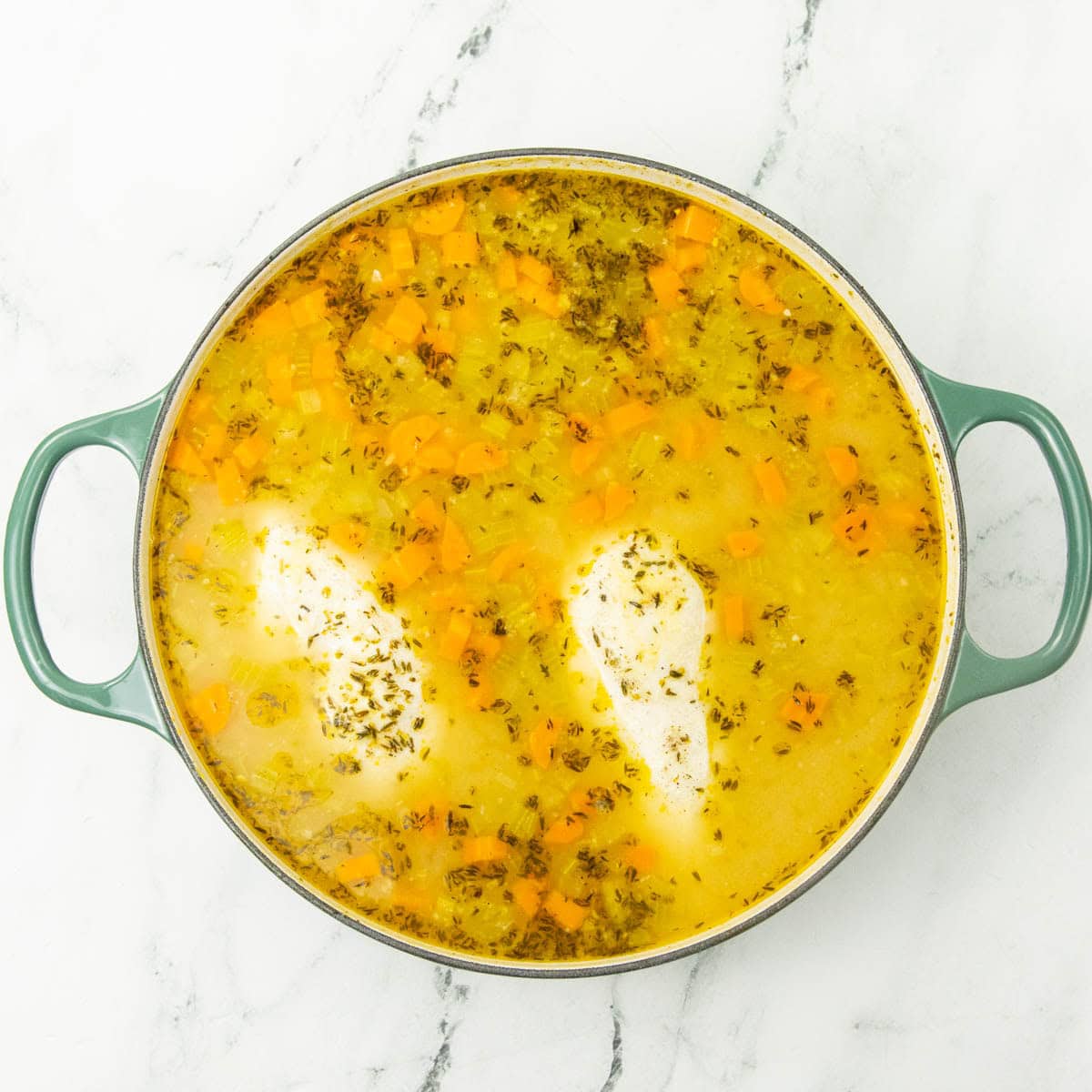 cooking chicken in broth of chicken noodle soup