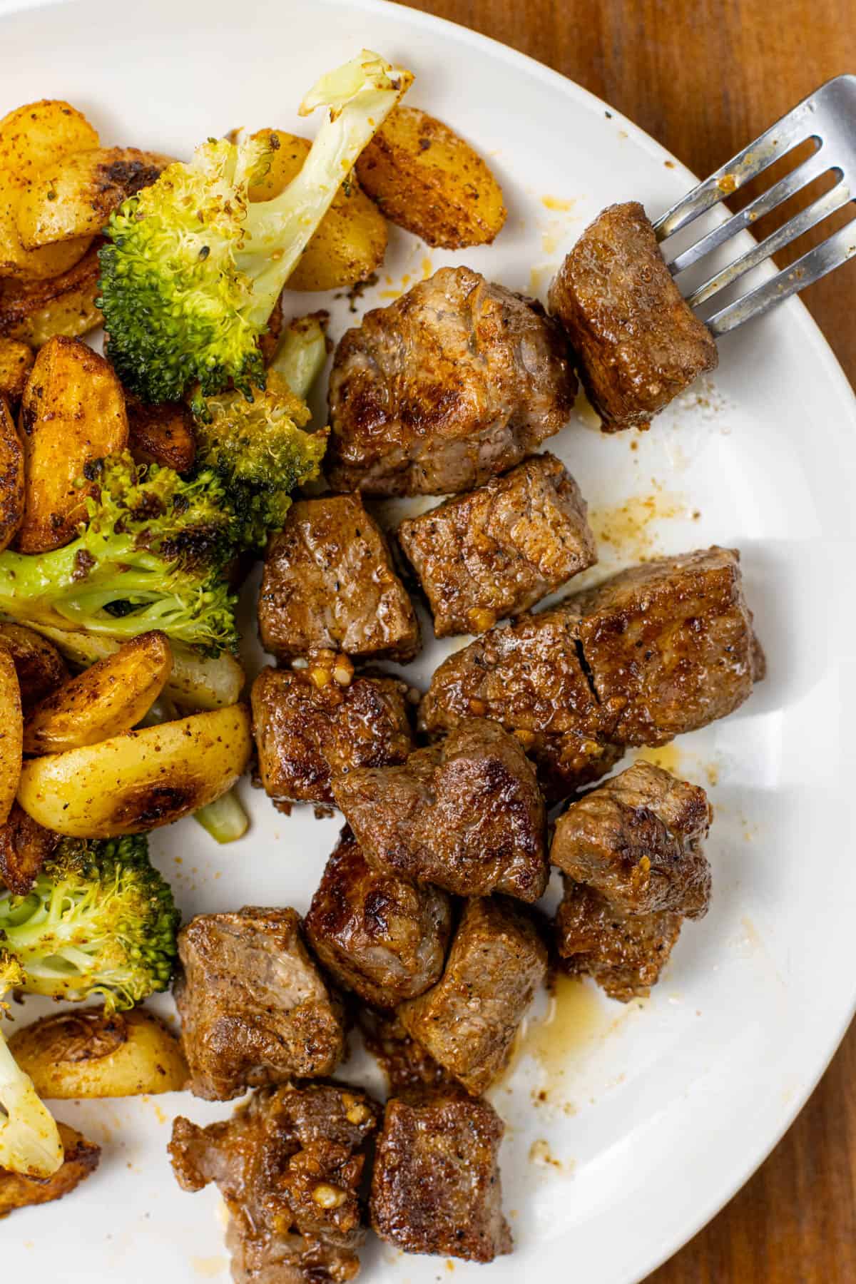 Garlic Butter Steak Bite on a plate with Potatoes and Broccoli 